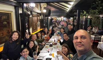 Group enjoying a meal at a restaurant, raising glasses.