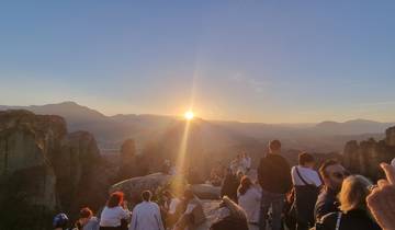 Group of people watching sunset over the mountains.