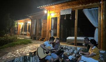 People enjoying music and tea on a porch at night.