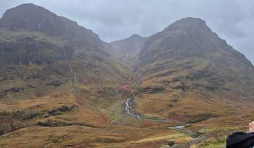 Valley with steep hills and a group of people posing.