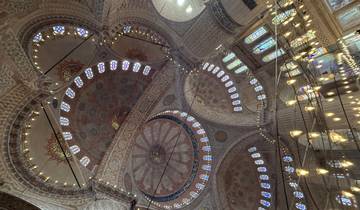 An ornate domed ceiling inside a mosque.