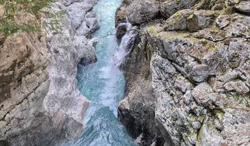 Turquoise river cutting through rocky cliffs.
