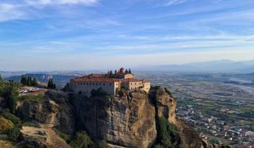 Monastery perched on a rock with landscape view.