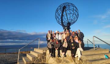 Group photo at a monumental globe by the sea.
