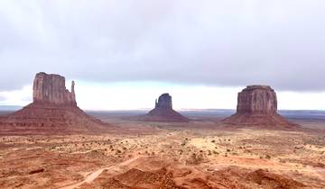 Monument Valley rock formations under a cloudy sky.