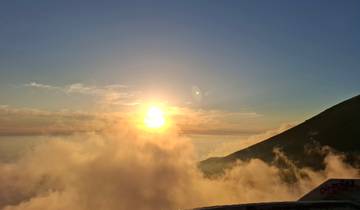 Sunset view with clouds and a hill silhouette.