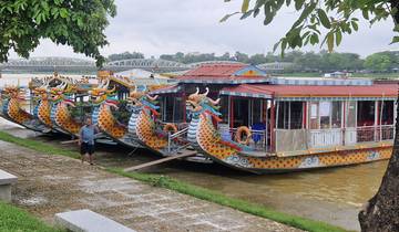 Colorful dragon boats docked along a river.