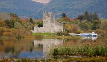 A lakeside castle surrounded by autumn trees.