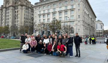 Group posing in front of a historic building with statues.