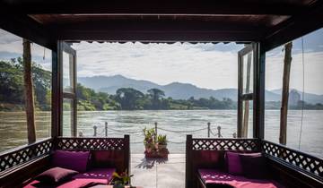 View from a boat showing a river flanked by hills.