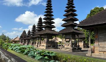 Traditional Balinese temple with multiple pagodas and lotus pond.