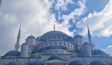 Blue Mosque with its striking domes and minarets under a partly cloudy sky.