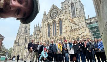 A group photo of people in front of a cathedral with elaborate architecture.