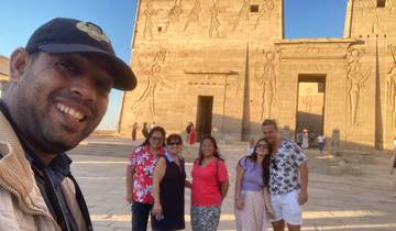 Group posing in front of ancient Egyptian temple reliefs.