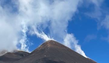Smoking peak of a volcanic mountain under a clear sky