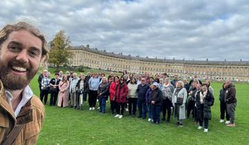 Large group posing in front of a historic crescent building