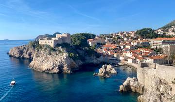 Aerial view of Dubrovnik with orange rooftops and blue sea.