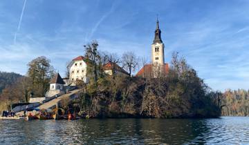 A church on an island surrounded by water and trees.
