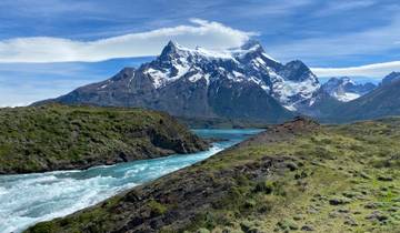 Dramatic mountain landscape with snow-capped peaks and a river.