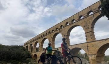 Cyclists posing in front of an aqueduct.