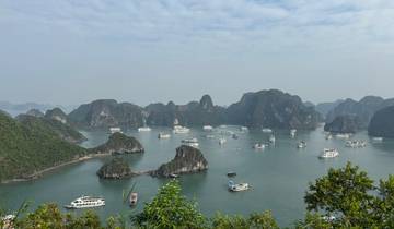 Many boats sailing past islands in bay.