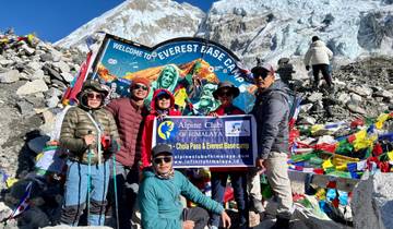 Group at Everest Base Camp with colorful flags.