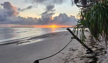 Sunset on a beach with dramatic clouds.