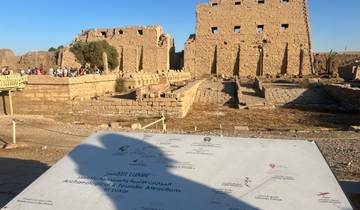 Tourist site with ruins and informational sign in Luxor.