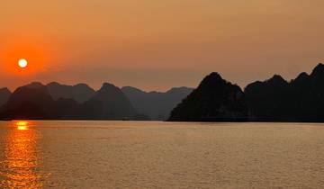 Sunset over water with mountains in the background.