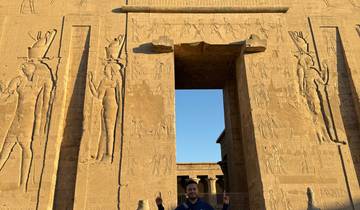 Front view of an ancient temple with carvings and a person.