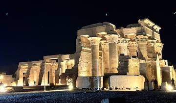 Illuminated columns of an ancient temple at night.
