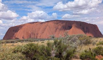 Uluru rock formation under a blue sky.