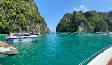 Limestone cliffs and boats on a turquoise sea.