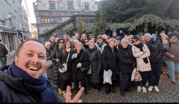 A large group of tourists posing in a city square.
