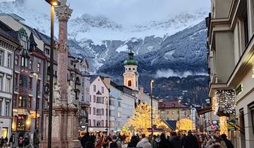 Crowded street with festive decorations and mountains in background.
