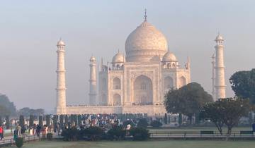 Taj Mahal with visitors in a garden setting.