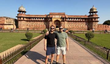 Two men posing in front of a large fort.