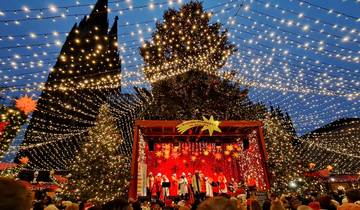 Stage performance with people at a Christmas market.