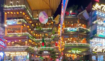 Vibrant street market at night with illuminated decorations.
