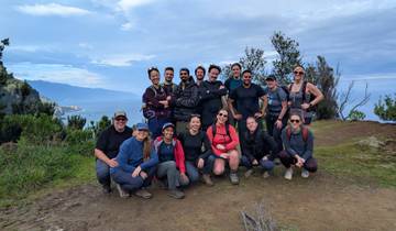 Group of hikers posing on a trail with a scenic background.