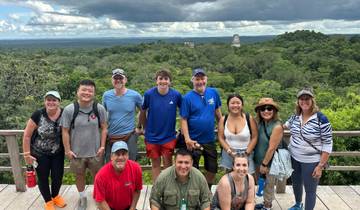 Large group posing with jungle and ancient structures.
