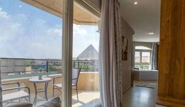 View of the pyramids from a hotel room with balcony seating.