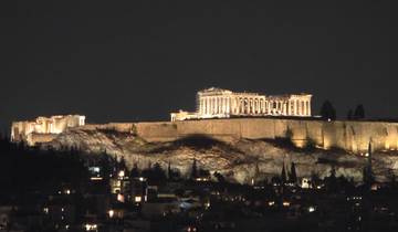 Night view of a lit Acropolis against a dark sky.