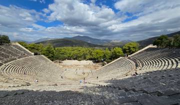 Open-air ancient theater amidst scenic mountains.