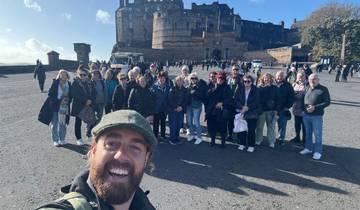 A large group of people posing near Edinburgh Castle.