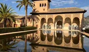 Reflective pool with a historic building featuring arches.