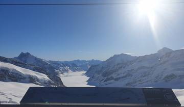 Snow-covered mountain landscape under a clear blue sky.