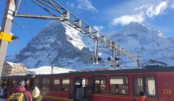 Train station with snow-capped mountains in the background.