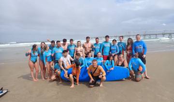 Group of people on a beach with surfboards.