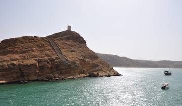 Coastal cliffs with a historic tower overlooking the sea.